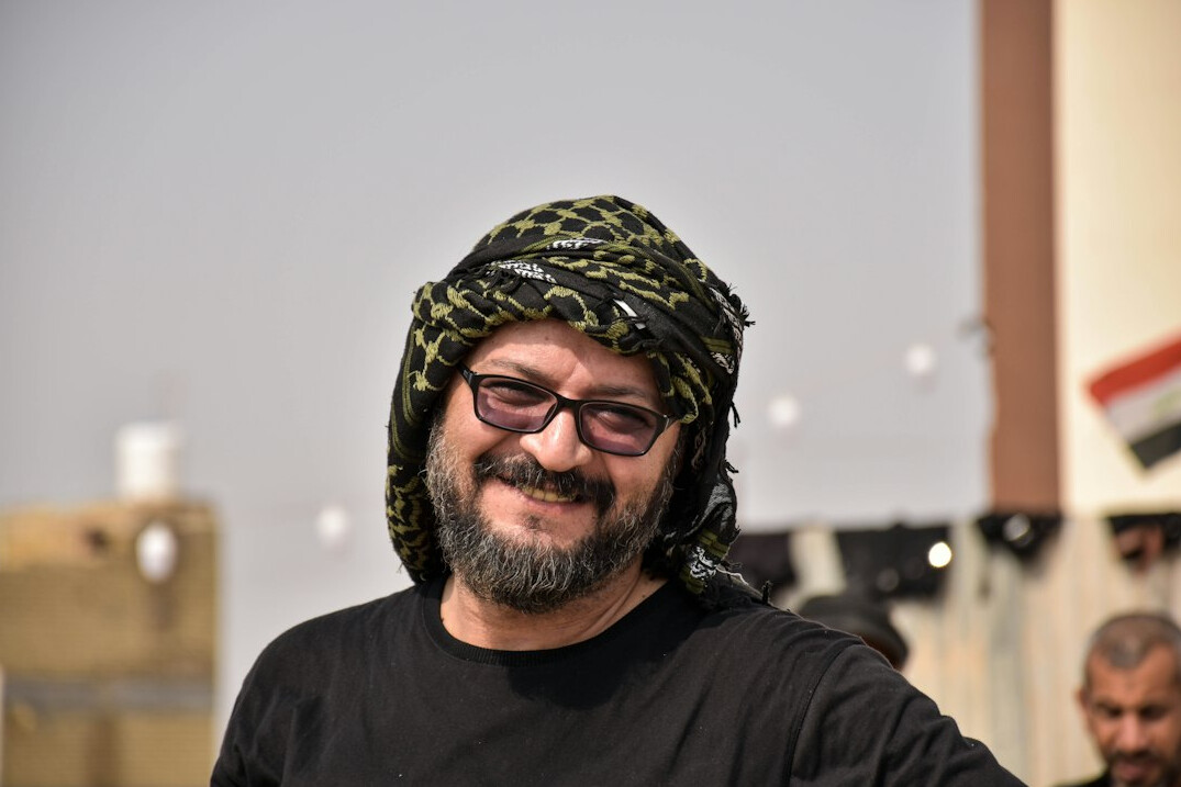Turkish man in glasses smiling, professional headshot