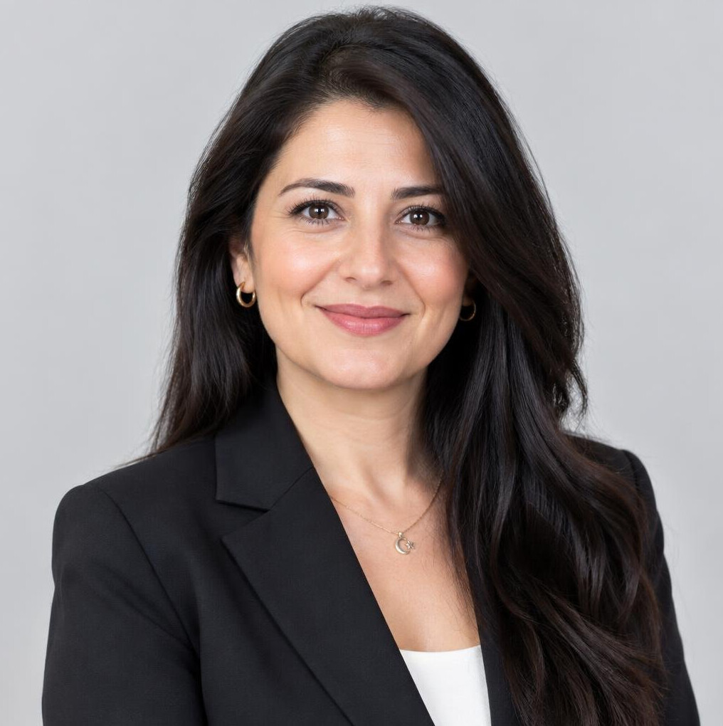Turkish woman with dark hair smiling, professional headshot